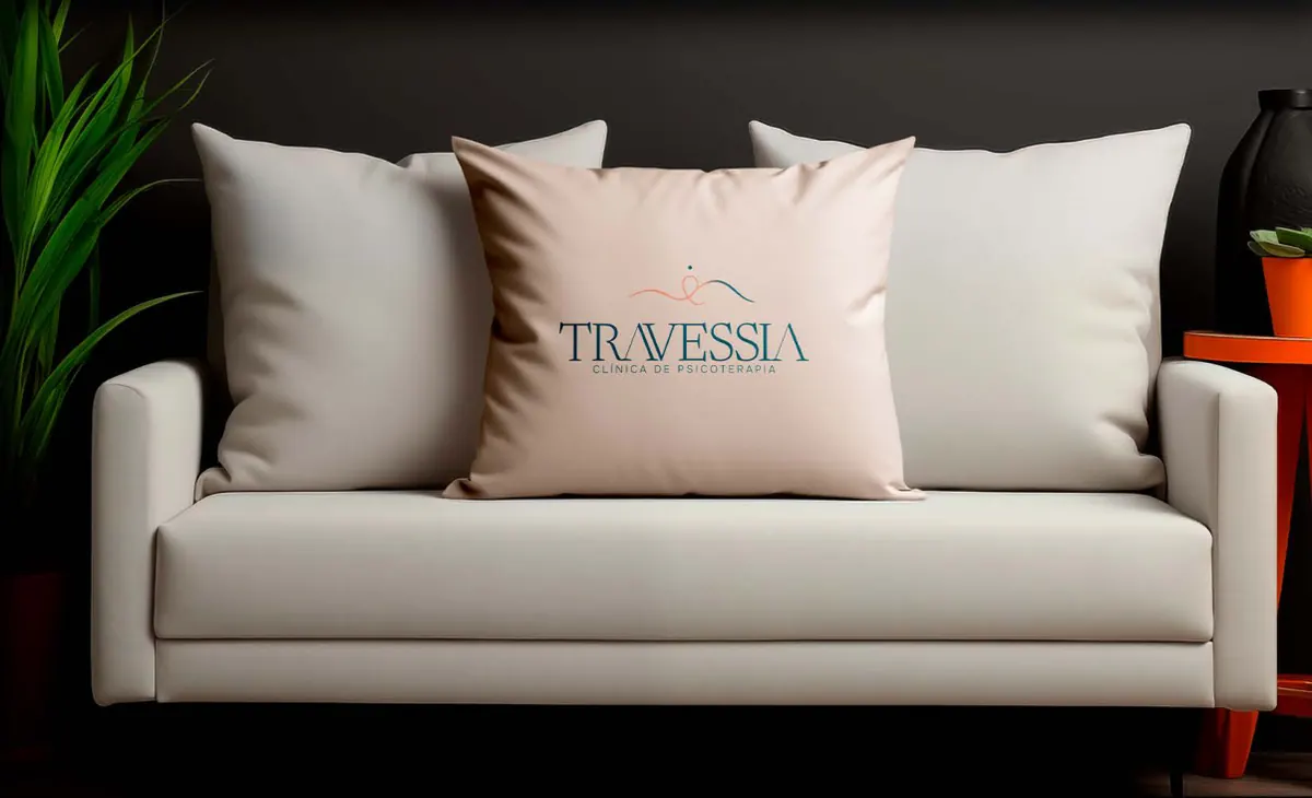 Almofada com o logo da Travessia em um sofá